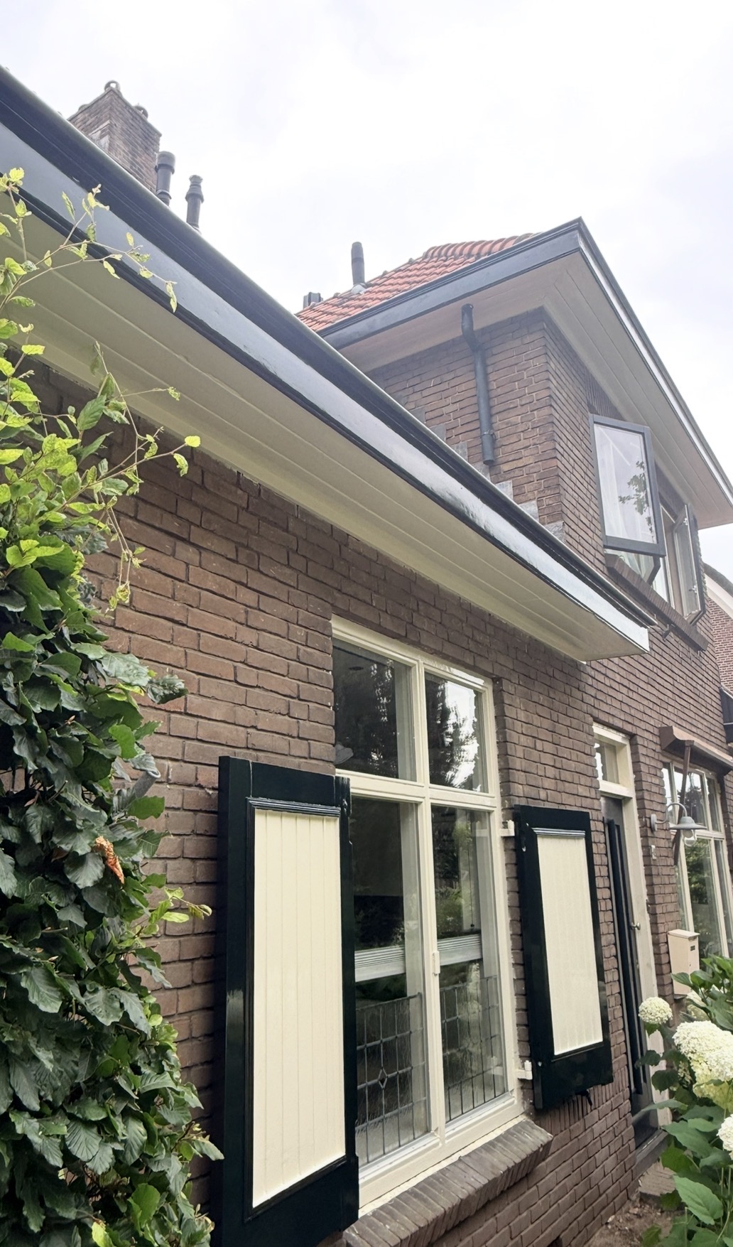 Buitenschilderwerk aan kozijnen, luiken, dakgoot en boeidelen van woning in Dieren door Bouwbedrijf Artifex